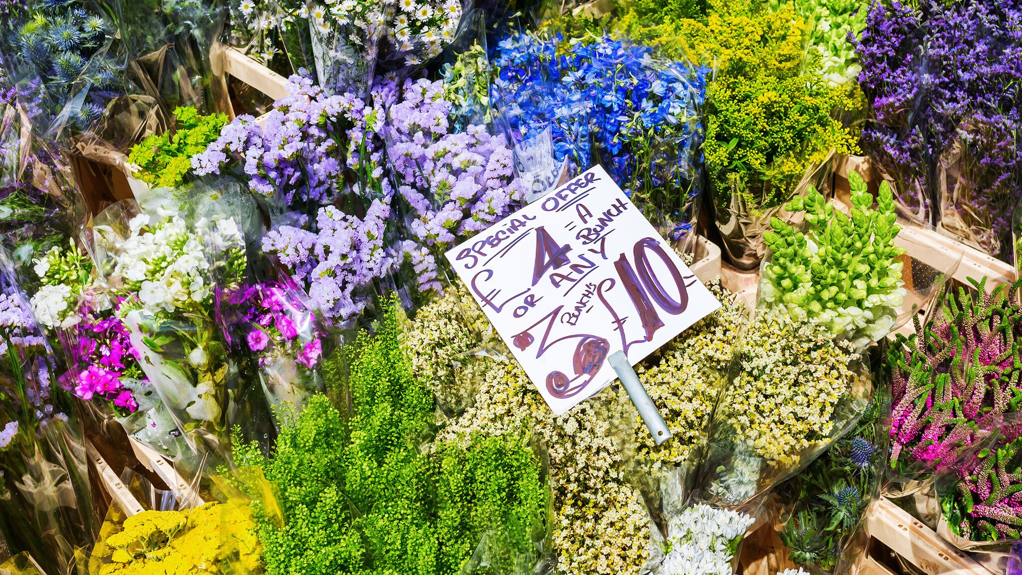 Nahaufnahme mehrerer Blumensträuße mit Preisschild an einem Marktstand.  