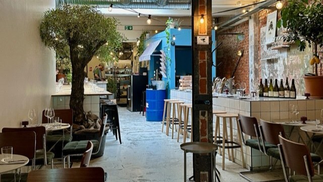 In einem Restaurant mit rustikalen Wänden steht eine Bar mit Hockern.
