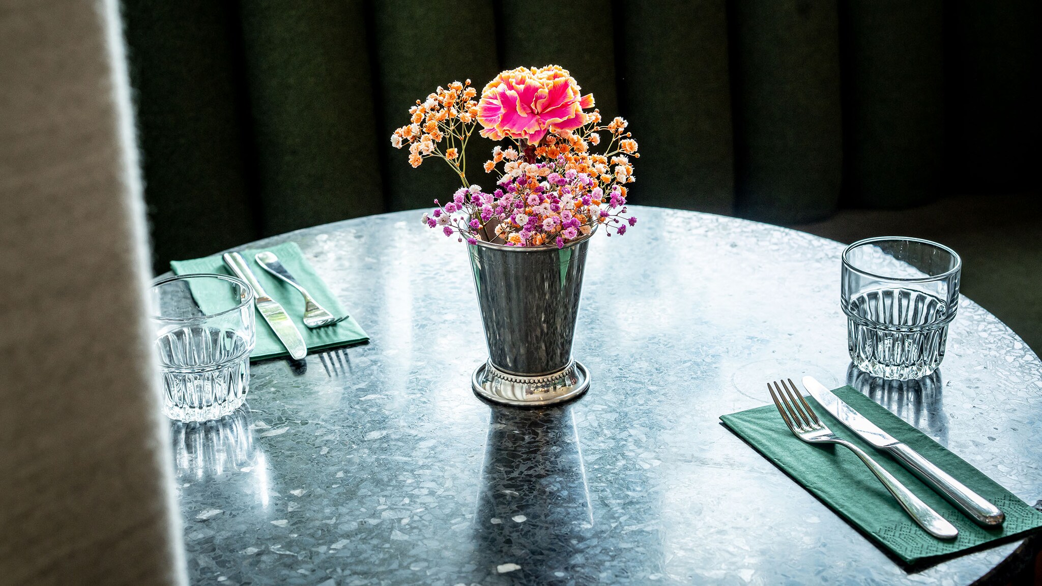  In einem Restaurant steht eine Blumenvase auf einem Marmortisch.
