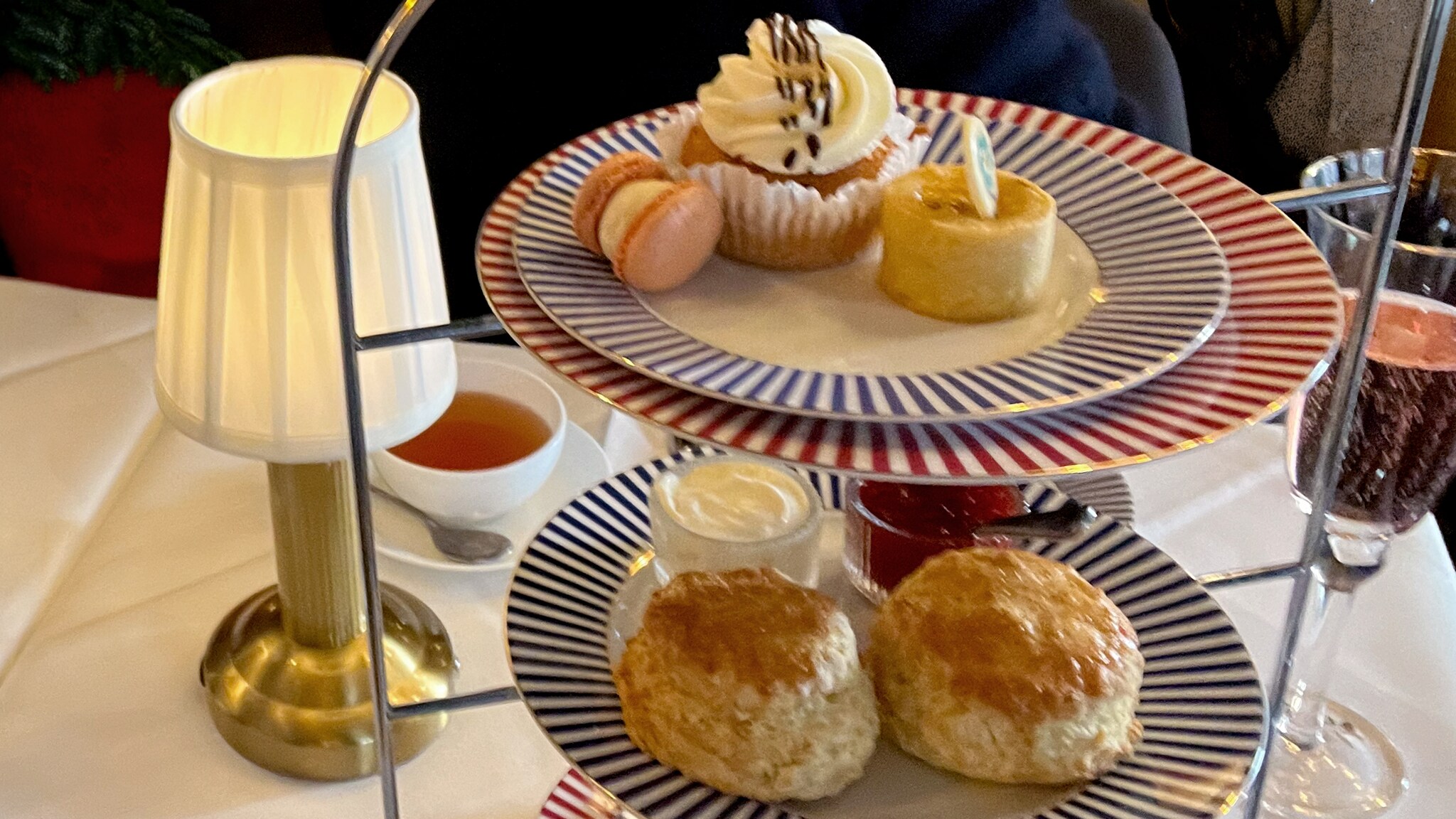 In einem Restaurant steht eine Etagere mit verschiedenen Muffins und Scones. 