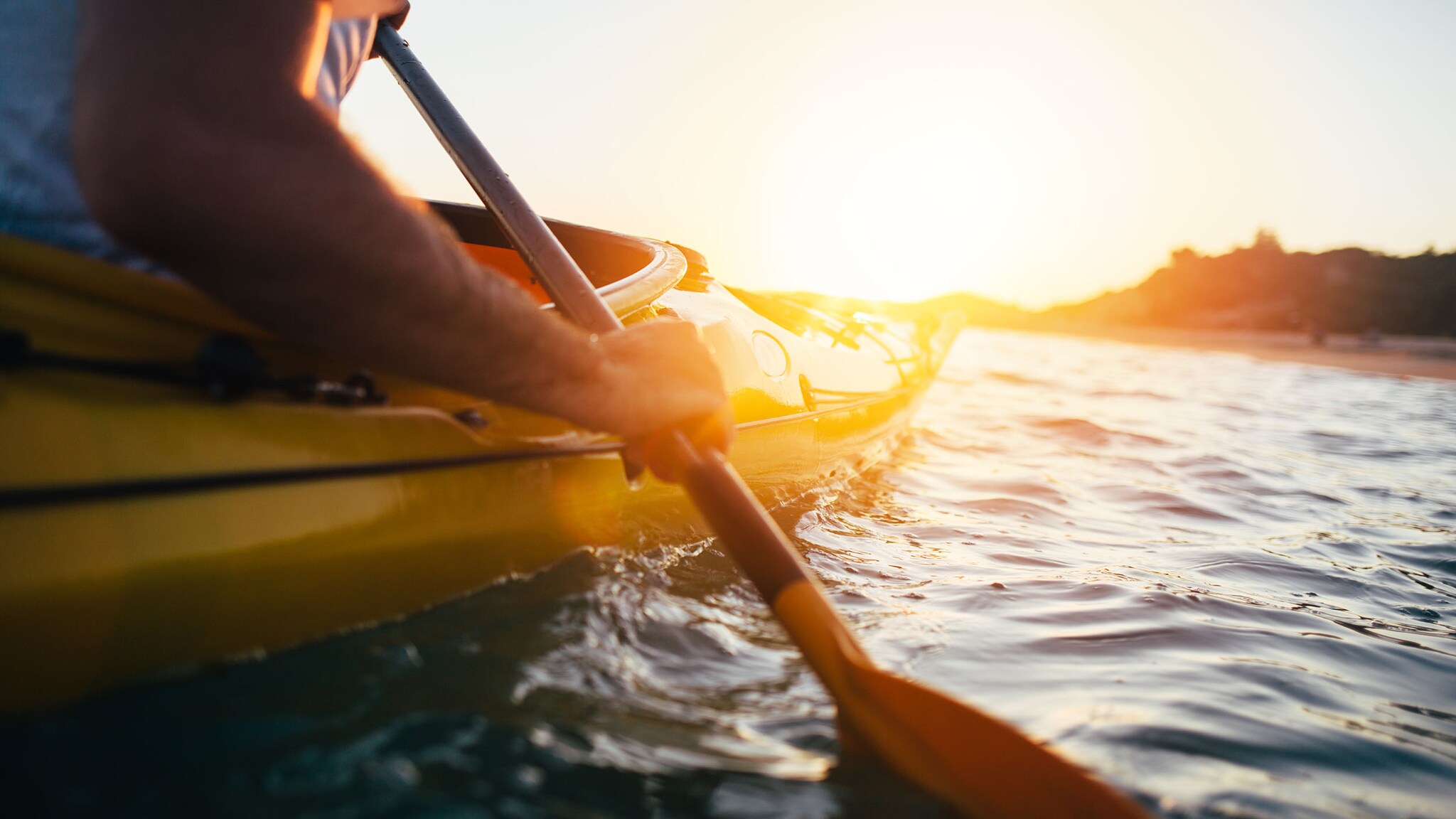 Eine Person fährt in einem Kanu auf einem See. 