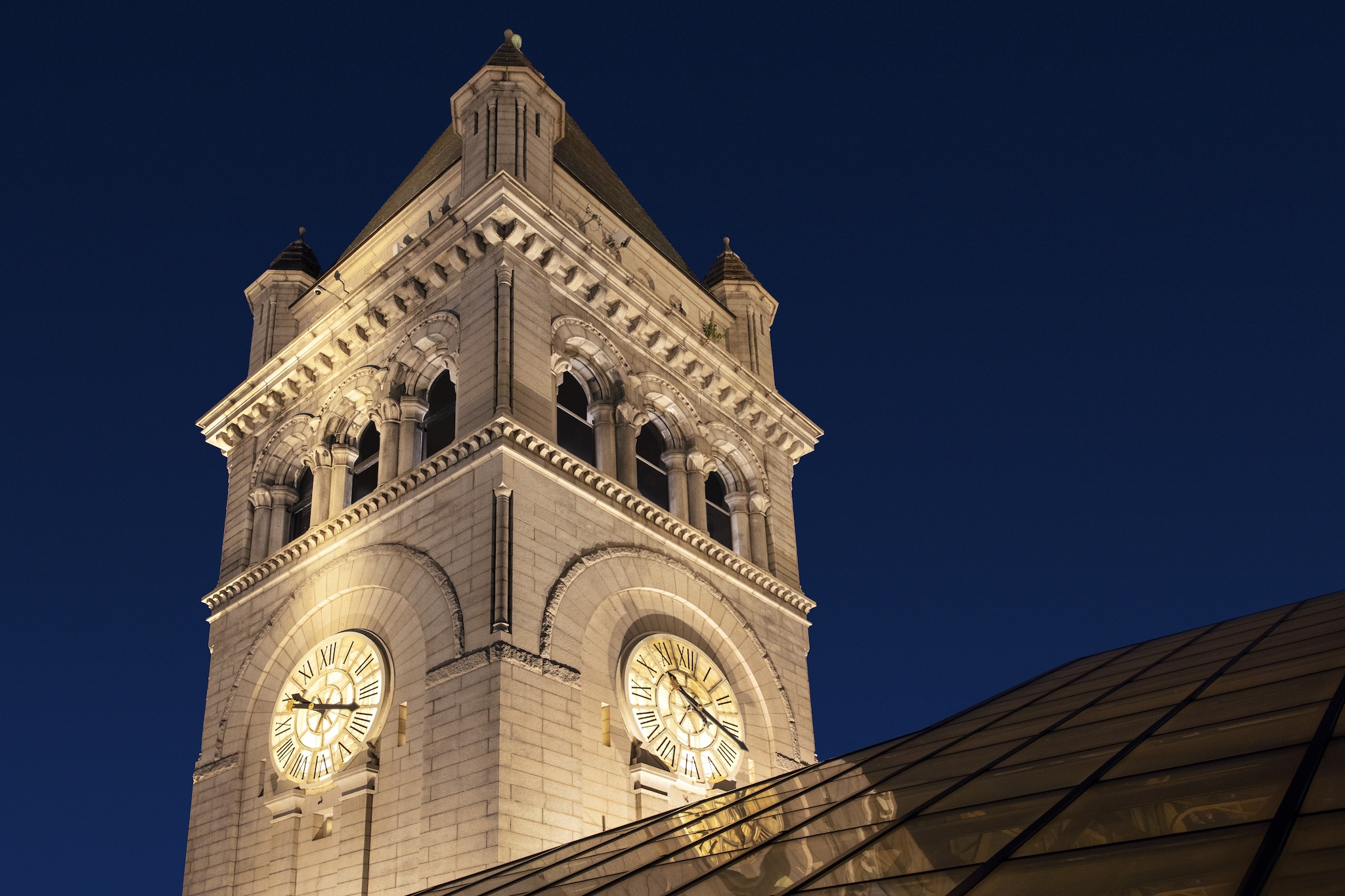 Der beleuchtete Uhrenturm des Old Post Office bei Nacht.
