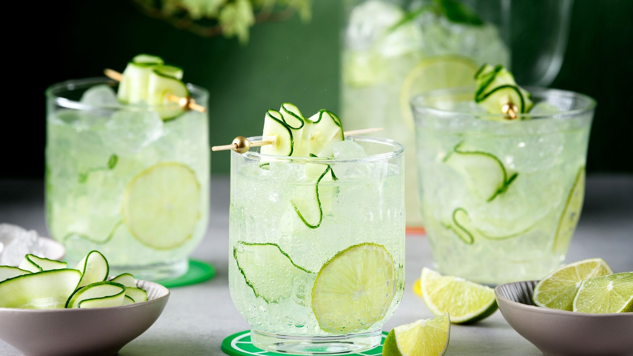 Gläser mit durchsichtigem Getränk mit Gurkenscheiben und Limette.