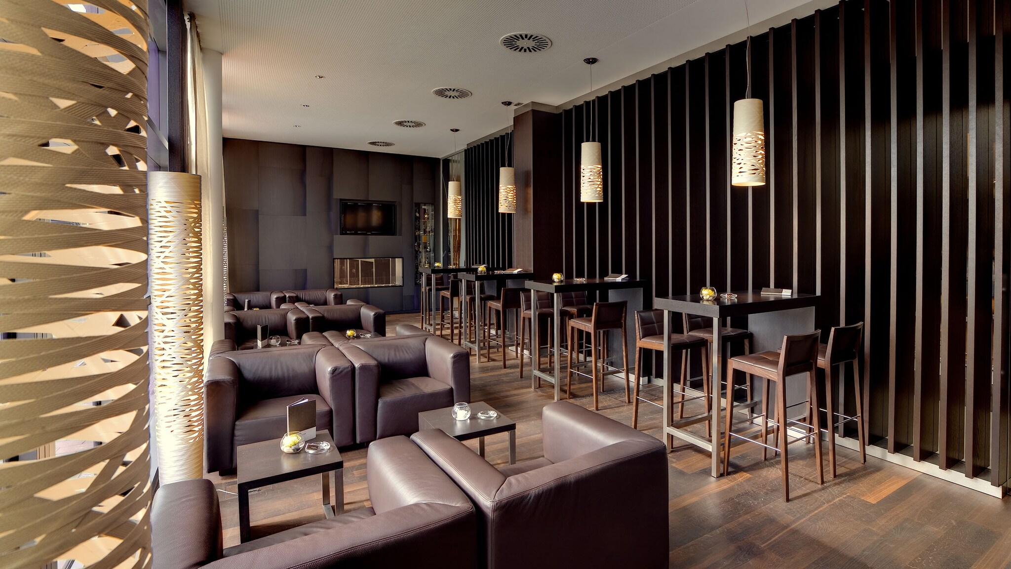 In dem Restaurant eines Hotels stehen Sessel und Stühle an Tischen.