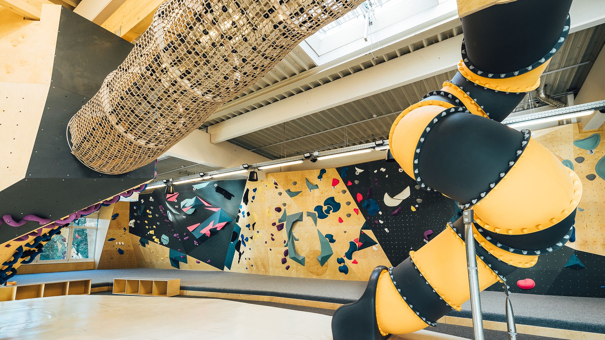 Vor einer Indoor-Bolder-Halle sind verschiedene Klettermöglichkeiten.