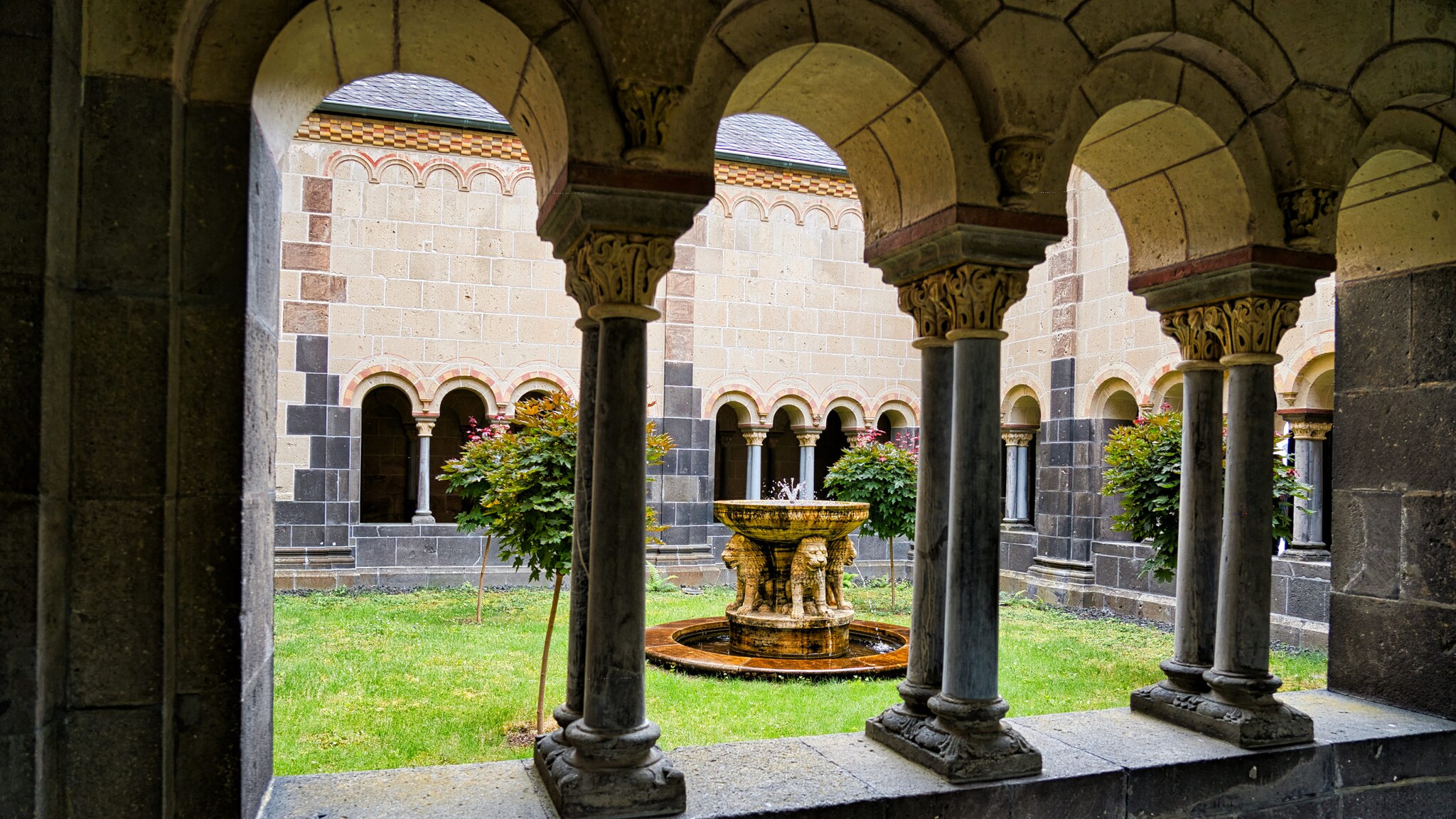 Blick auf den eingesäumten Löwenbrunnen der Abtei Maria Laach.