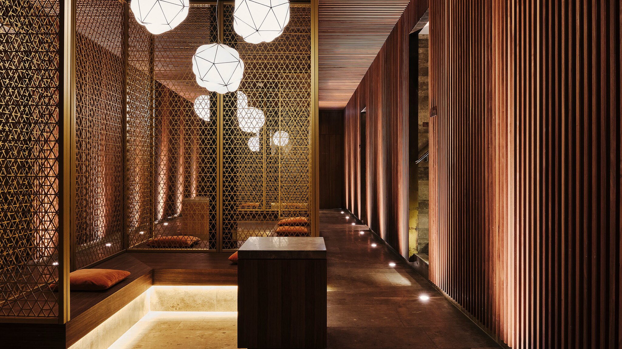 Sitzecken in einem stilvollen Spa-Bereich im japanischen Design in Brauntönen mit Holzverkleidungen an Wänden und Decke.