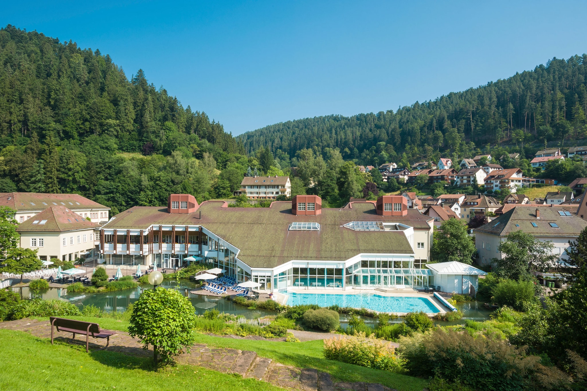 amex-magazin-wellness-schwarzwald-mineraltherme-bad-teinach Blick auf die Mineraltherme Bad Teinach mit, für den Schwarzwald so typischen dunkelgrünen Tannen im Hintergrund.