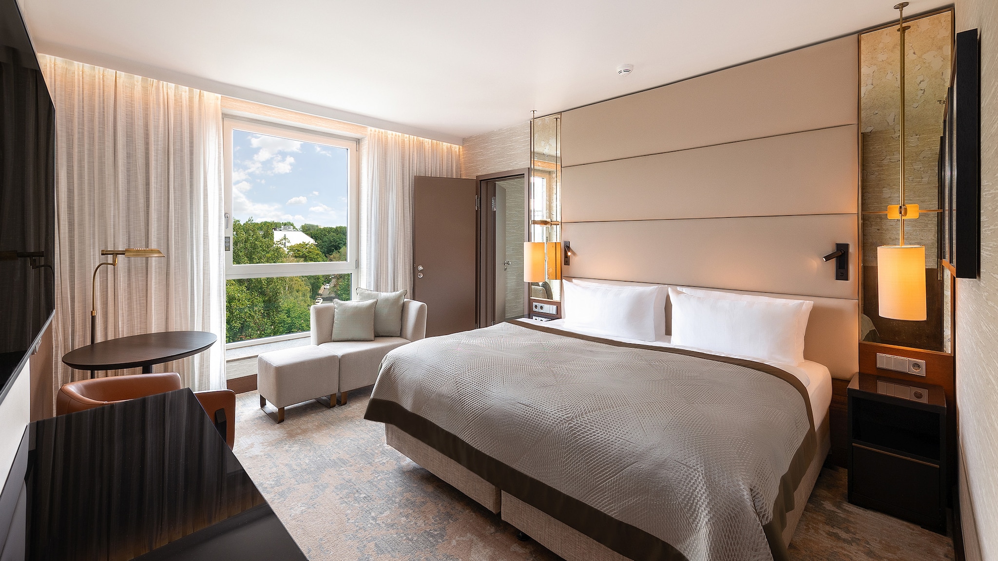 In einem Hotelzimmer steht ein Bett, umgeben von anderen Möbeln.