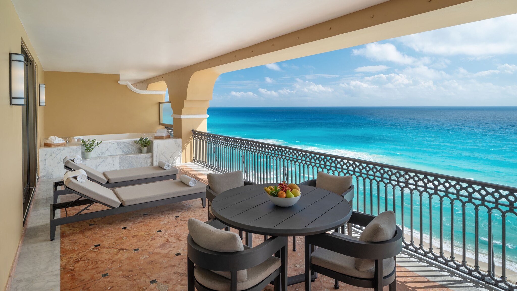 Auf der Terrasse einer Hotelsuite stehen Liegen und Sitzmöbel.