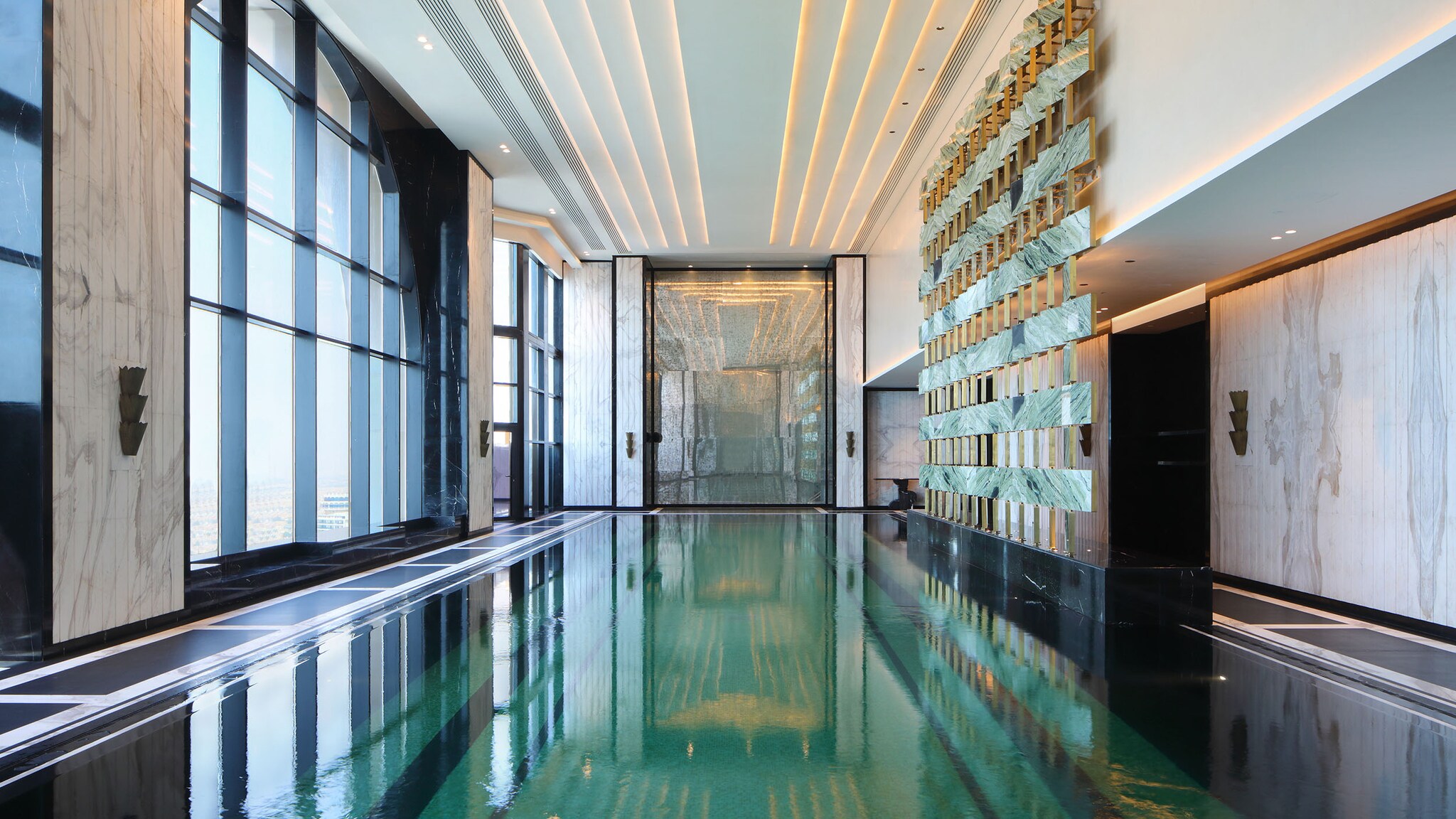 In einem Hotel-Spa ist ein großer Indoor-Pool umgeben von verzierten Wänden.