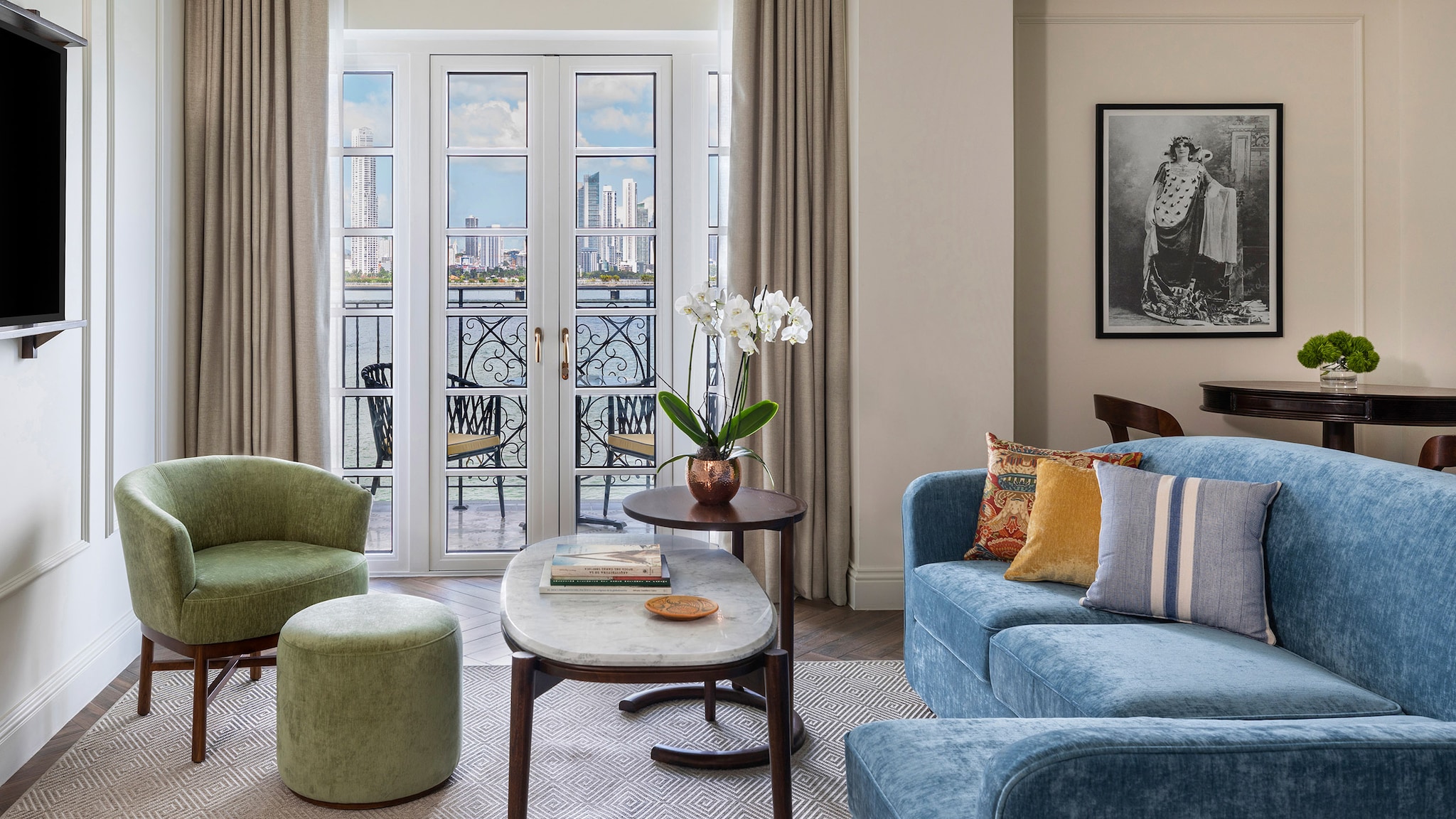 Luxuriöses Wohnzimmer einer Hotelsuite mit Blick auf eine Skyline.
