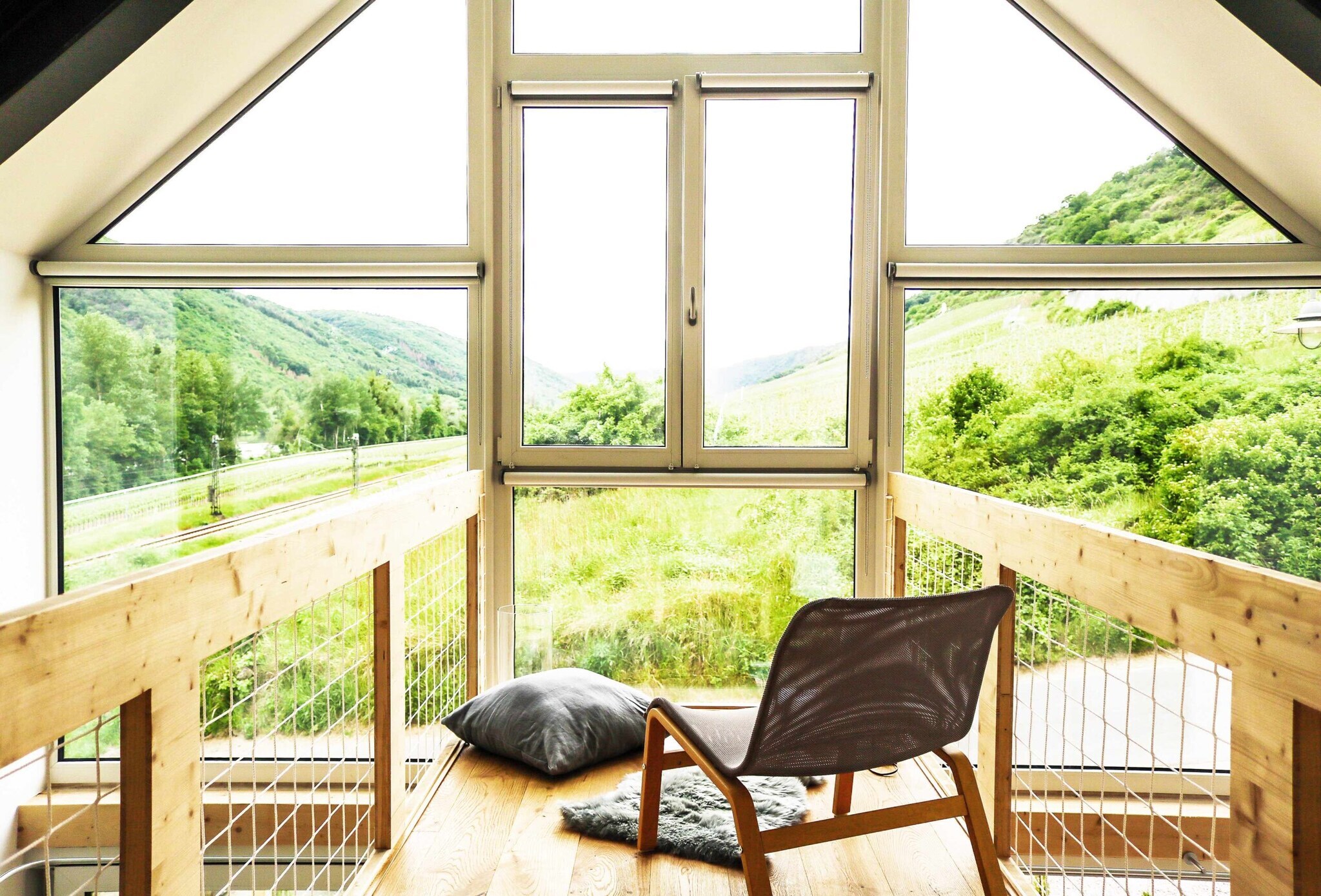 Ein Sessel vor einem Panoramafenster mit Blick auf die Weinberge Ein Sessel vor einem Panoramafenster mit Blick auf die Weinberge