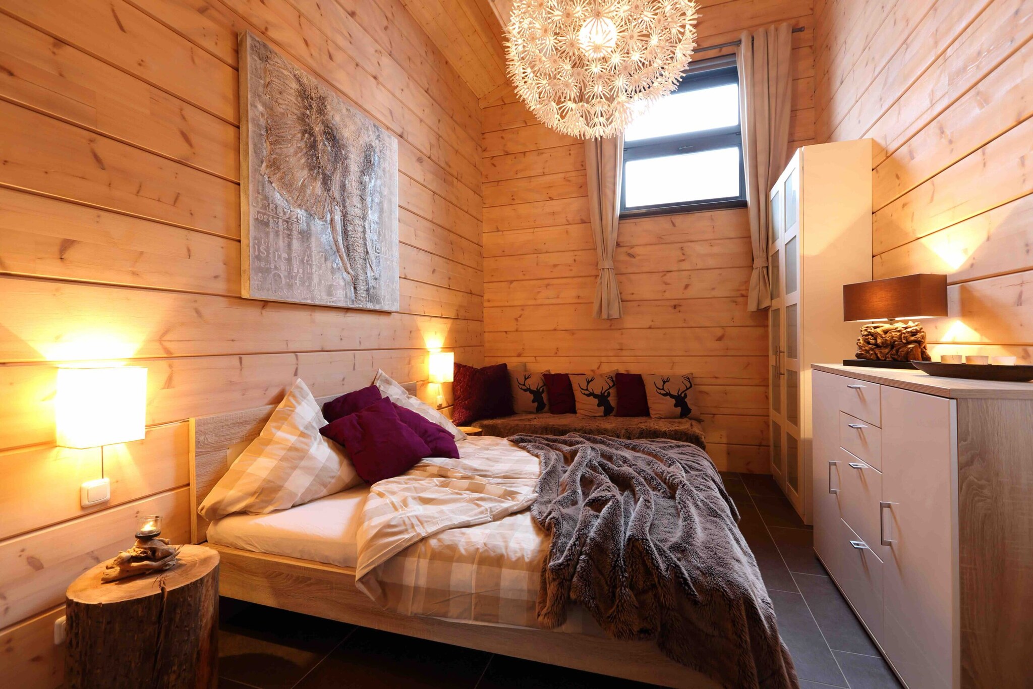 Ein gemütliches Bett in einem hellen Holzhaus Ein gemütliches Bett in einem hellen Holzhaus