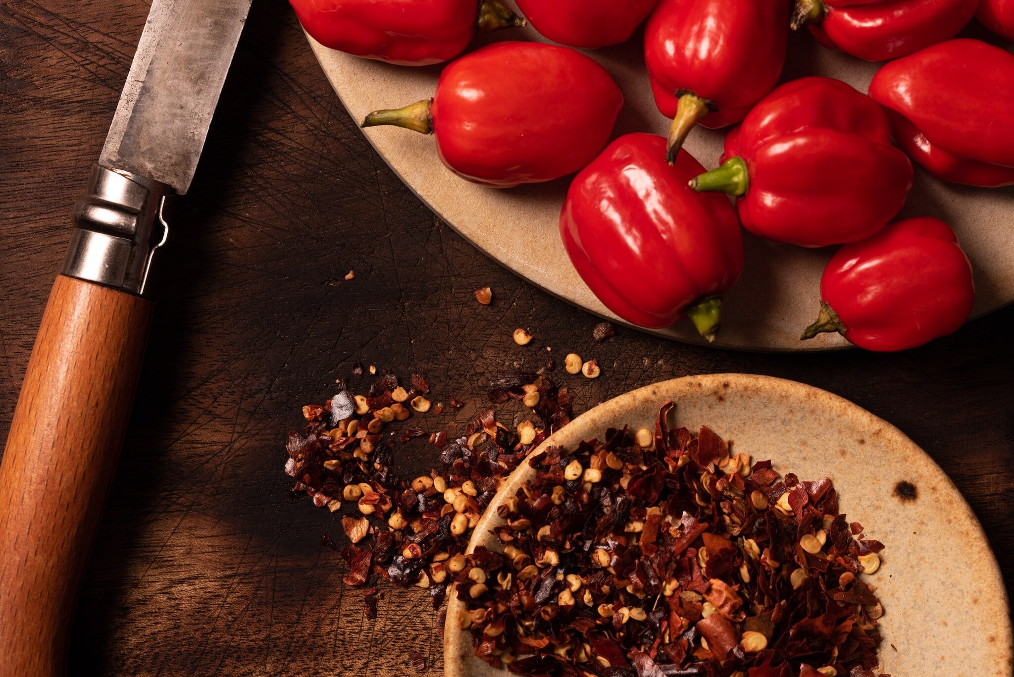 Vogelperspektive auf Tisch mit Chili Beeren sowie getrockneten Chilis Vogelperspektive auf Tisch mit Chili Beeren sowie getrockneten Chilis