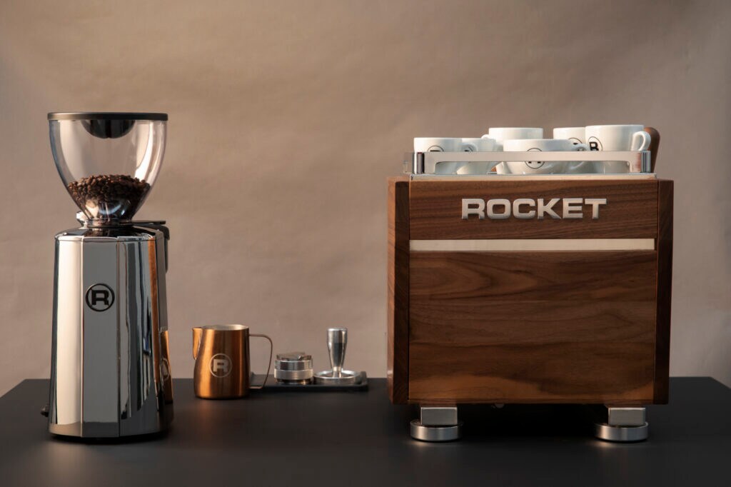 Edle Espressomaschine, Kaffeemühle und Milchkännchen auf einem Tisch