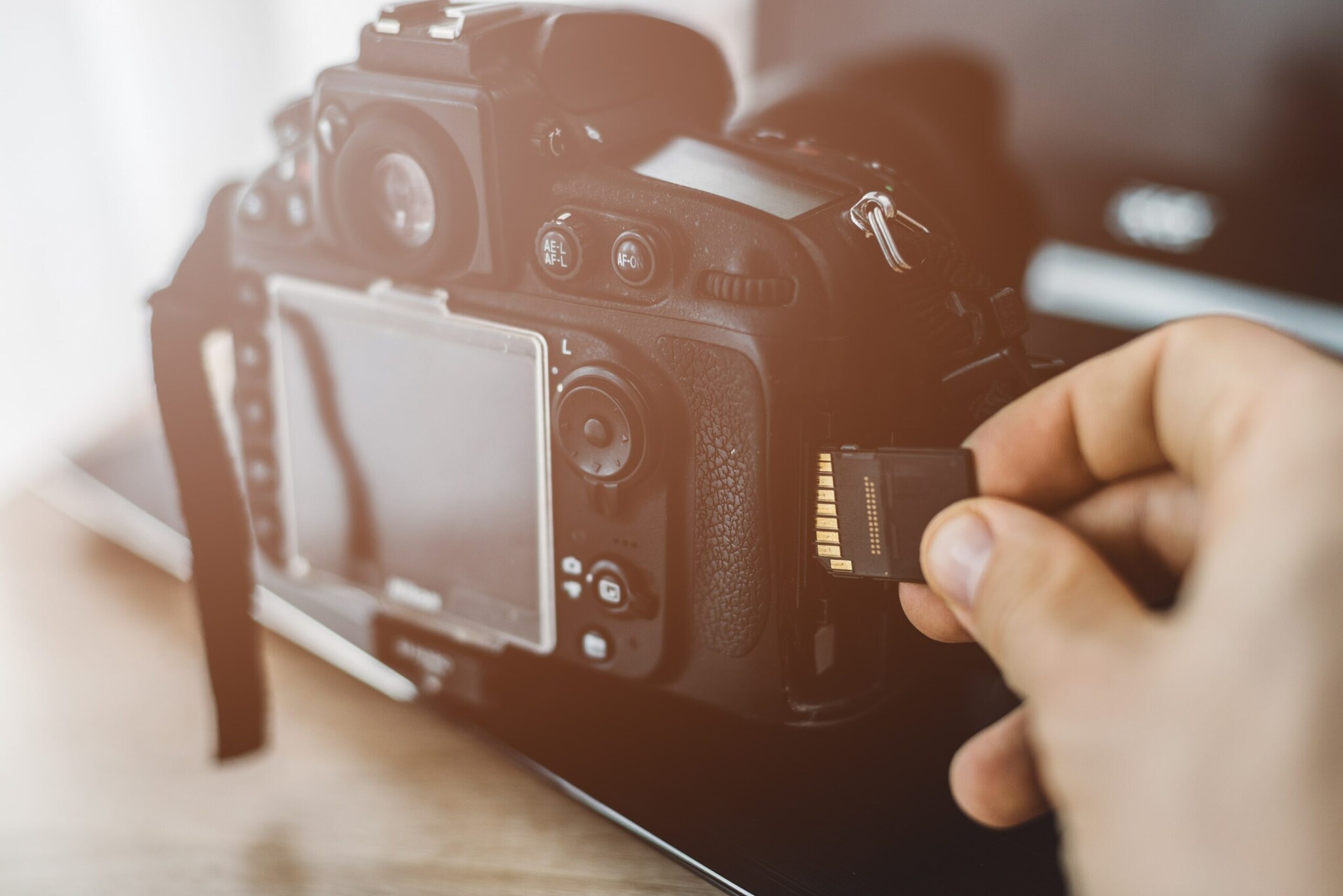 Eine Hand steckt eine Speicherkarte in einen Fotoapparat Eine Hand steckt eine Speicherkarte in einen Fotoapparat