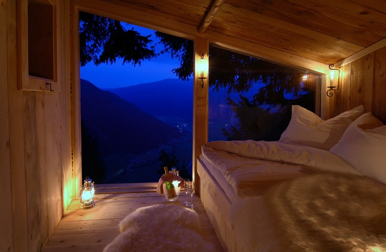 Ein Raum mit Wänden aus Holz mit einem Bett und Blick auf das Panorama Ein Raum mit Wänden aus Holz mit einem Bett und Blick auf das Panorama
