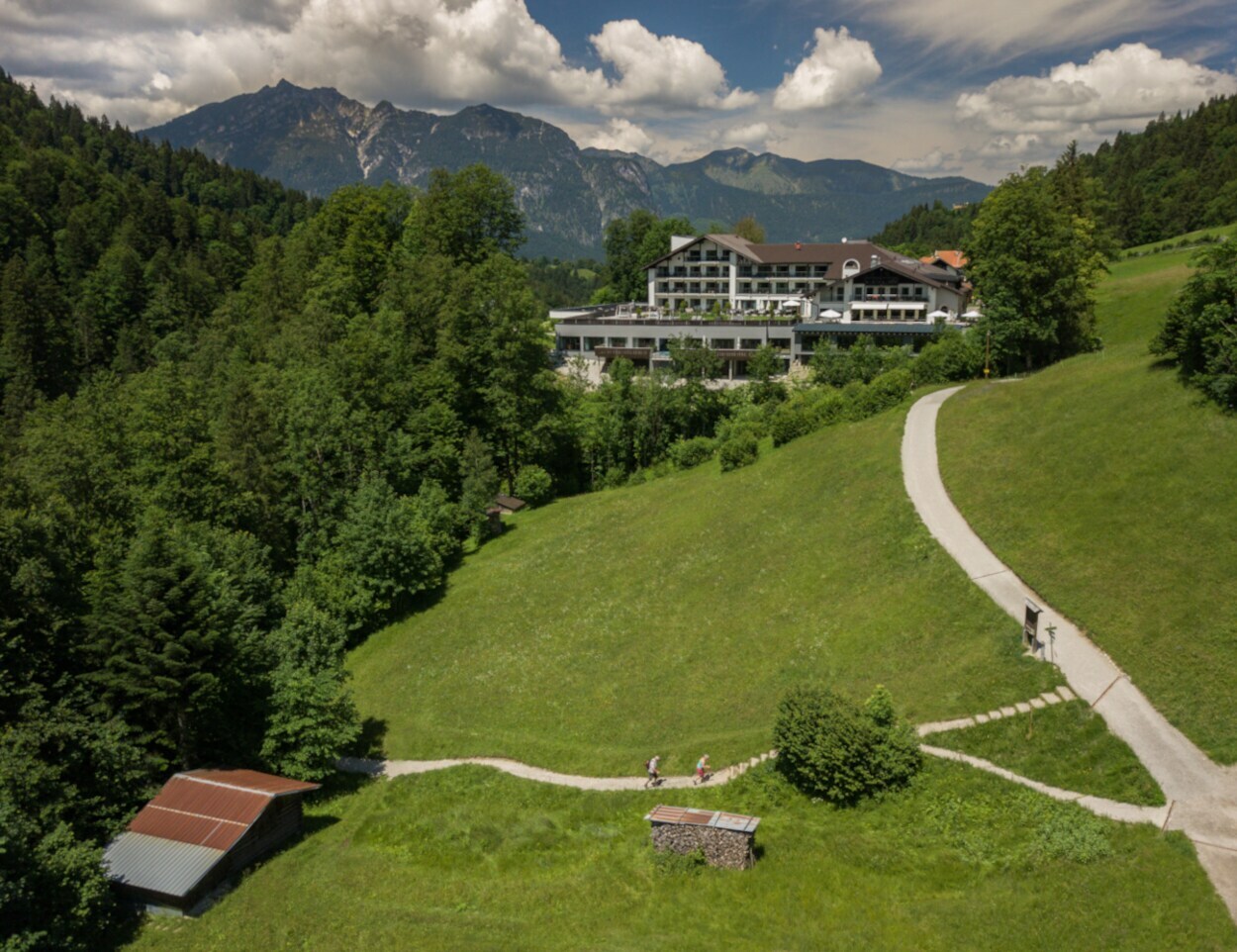 Ein großes Hotel liegt inmitten von Bergwiesen