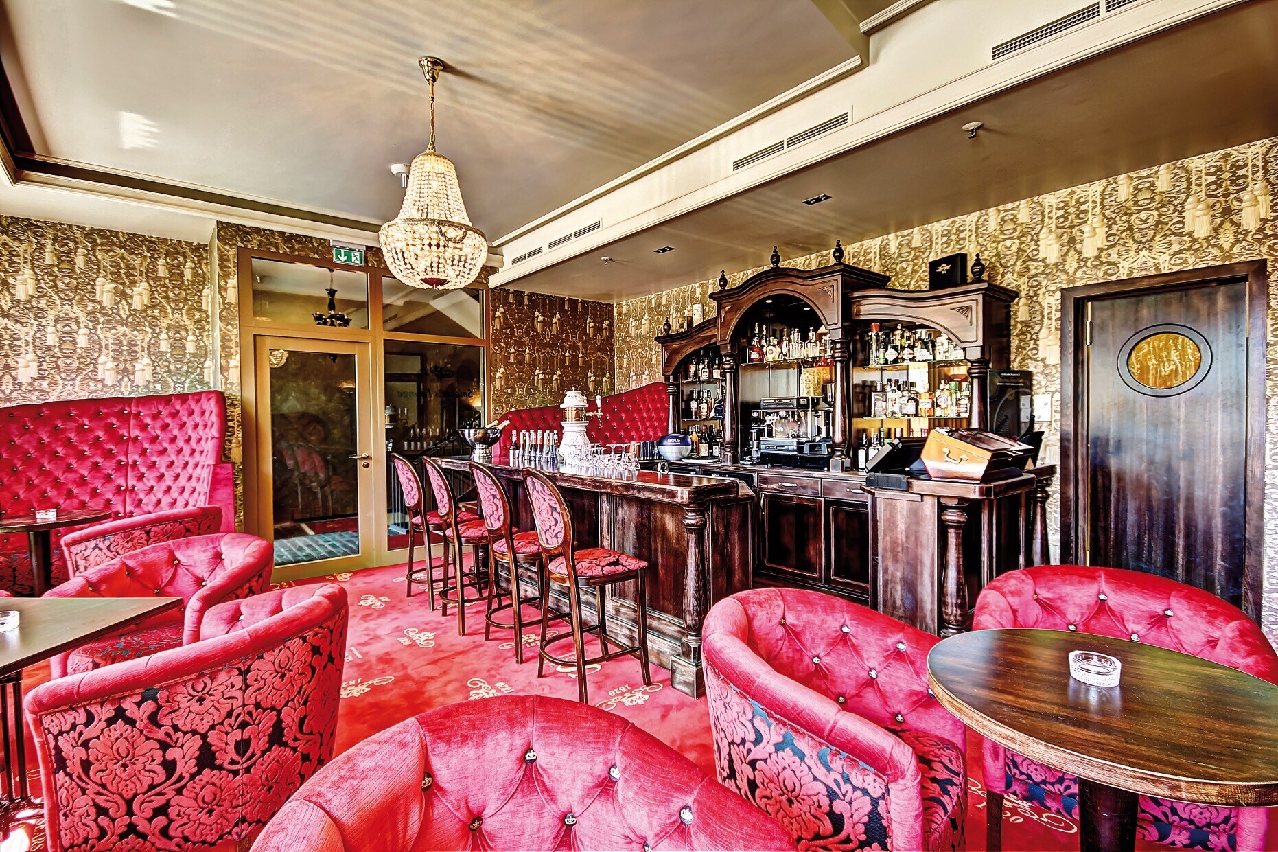 Eine Bar mit rotem Samtmobiliar im Stil der 1920er-Jahre