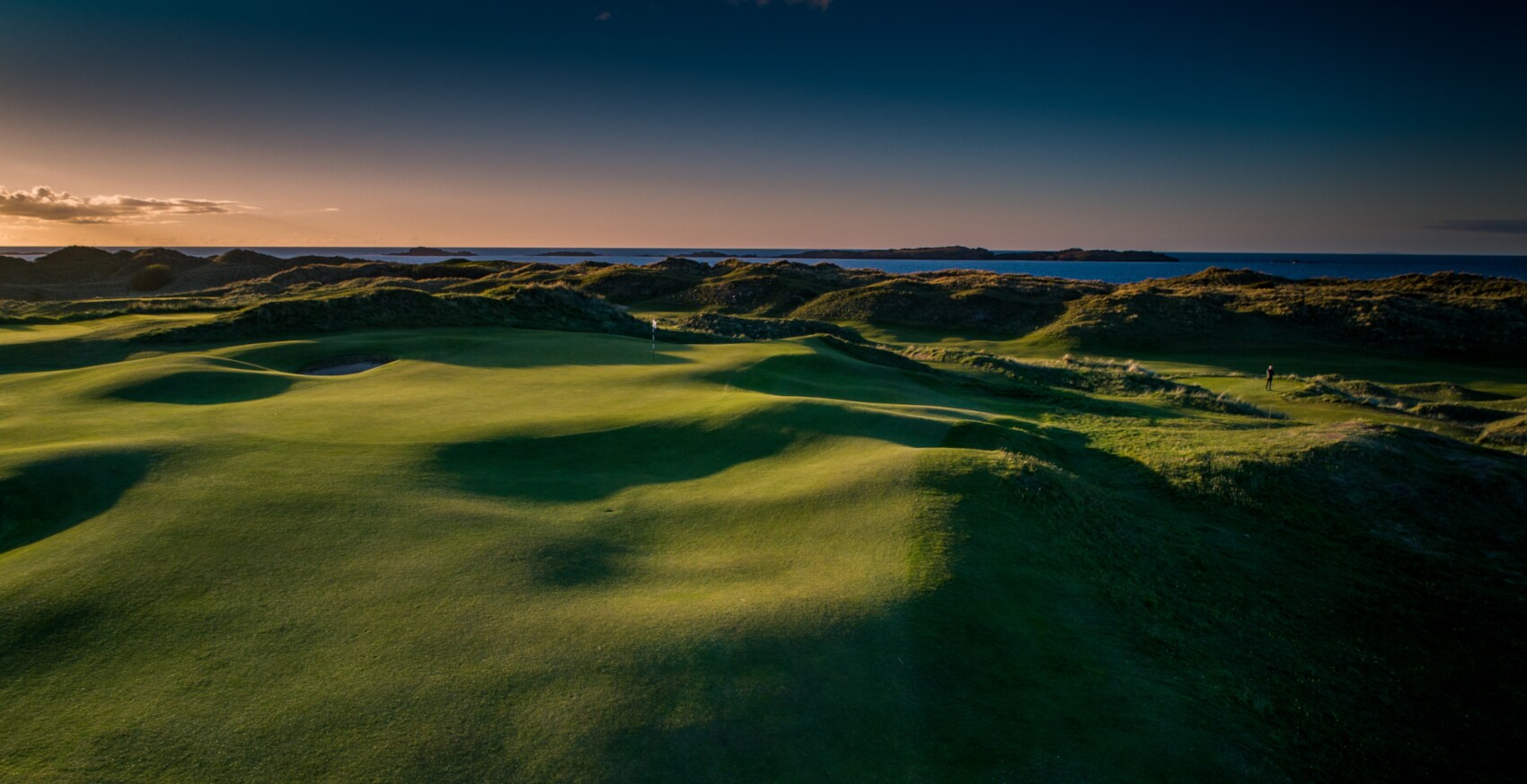 Eine hügelige Landschaft mit Blick auf das Meer