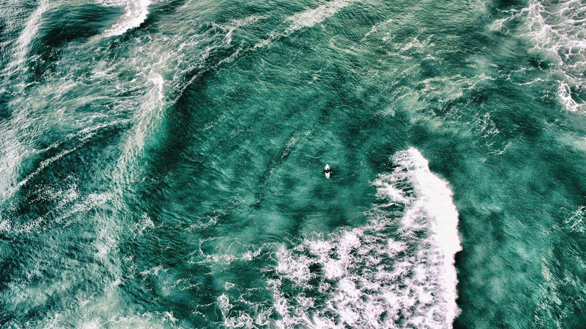 Wellenreiter:in auf einem Brett umgeben von Wasser Wellenreiter:in auf einem Brett umgeben von Wasser