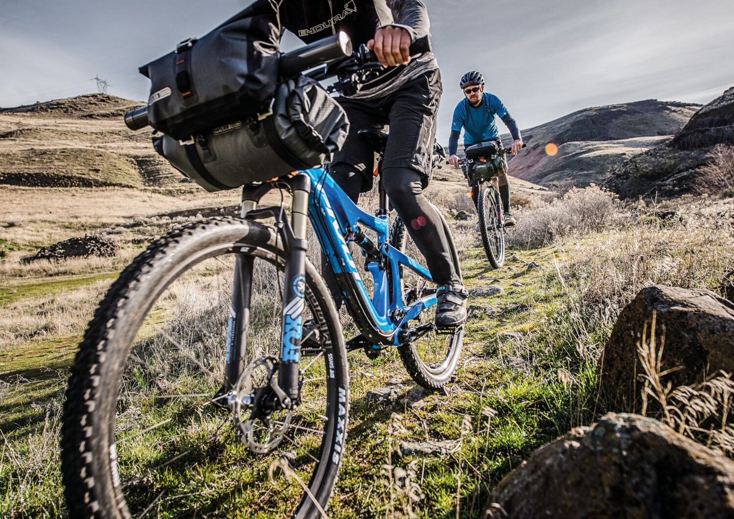 Zwei E-Mountainbikes hintereinander fahrend in einer kargen Berglandschaft