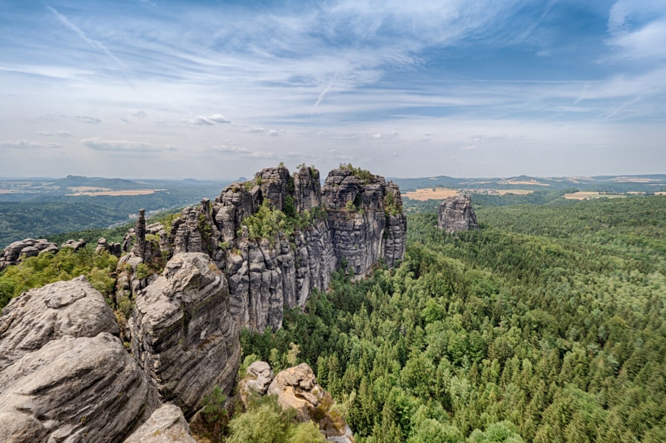 Blick auf die Felsenformation Schrammsteinkette, die aus dem Wald herausragt Blick auf die Felsenformation Schrammsteinkette, die aus dem Wald herausragt