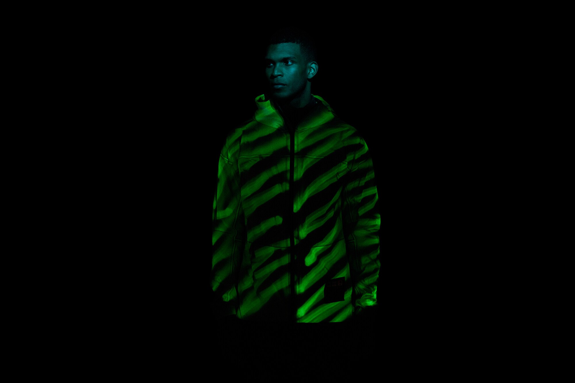 Mann trägt im Dunkeln eine gelb leuchtende Jacke