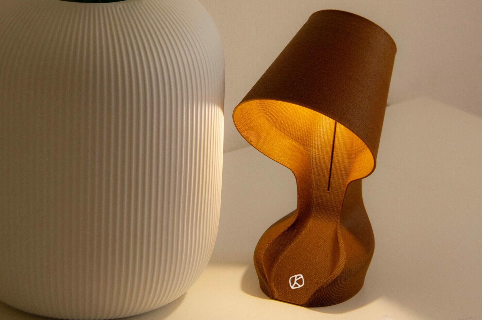 Eingeschaltete Schreibtischlampe und Vase auf weißem Untergrund