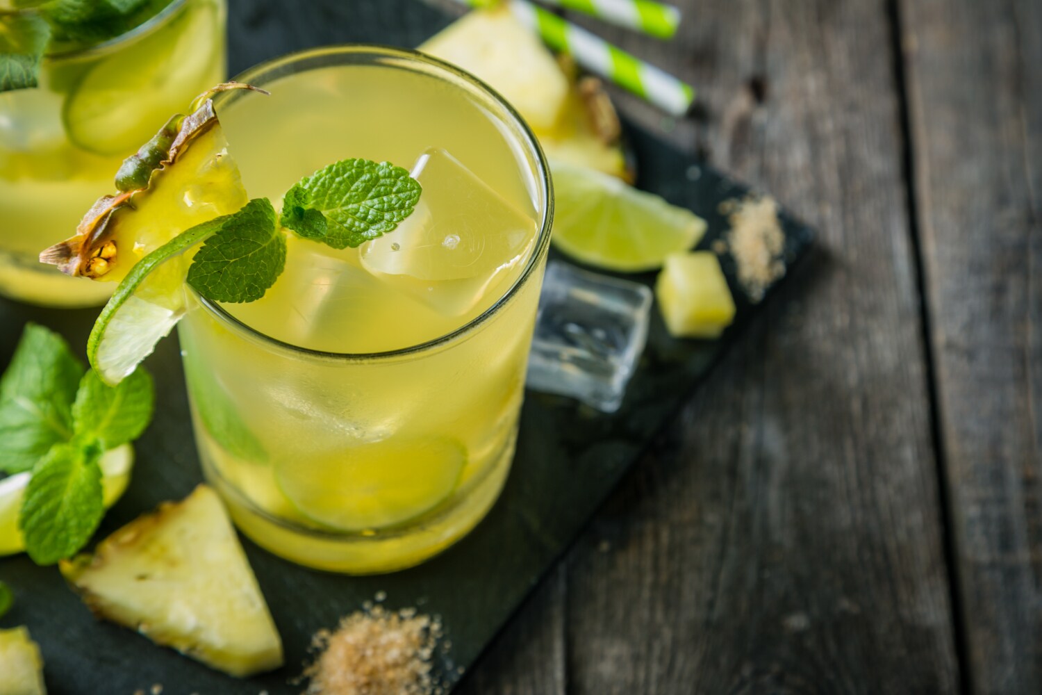 Ein Longdrink mit Minze, Limette, Ananas und Eiswürfeln