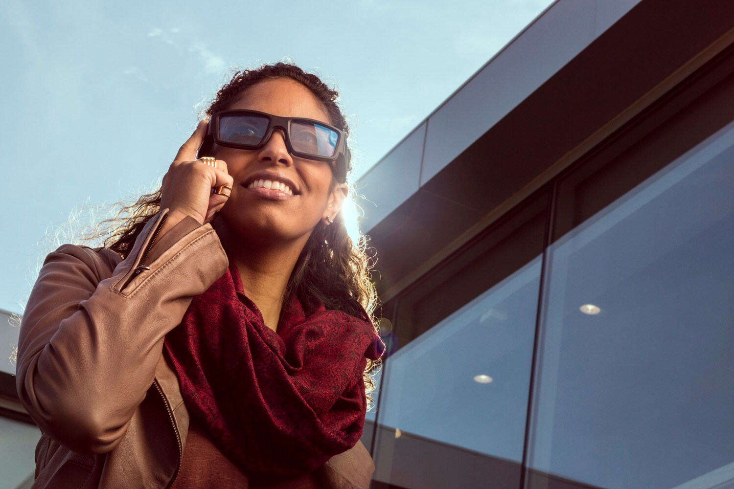 Eine Frau trägt eine Sonnenbrille die sie mit dem Fingern antippt