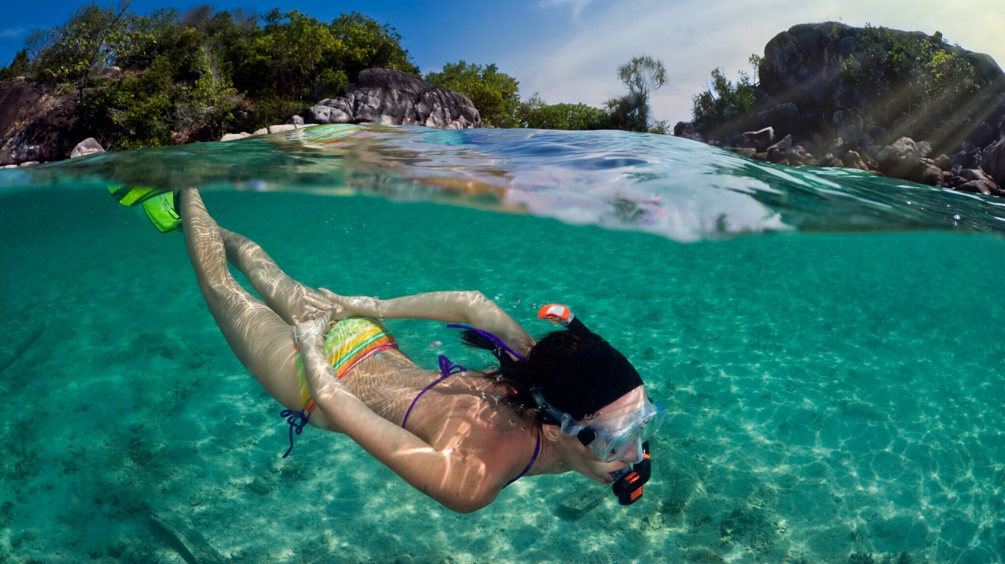 Frau schnorchelt vor einer tropischen Insel