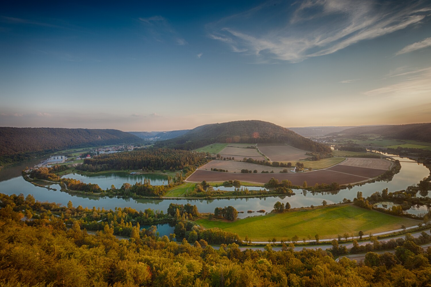 Blick auf eine Flussschleife die rund um eine Erhöhung führt