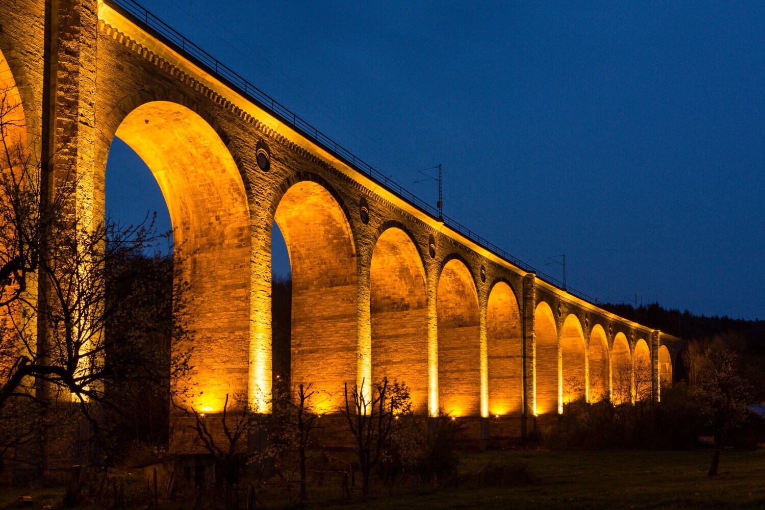 Hell beleuchtetes Viadukt bei Dunkelheit