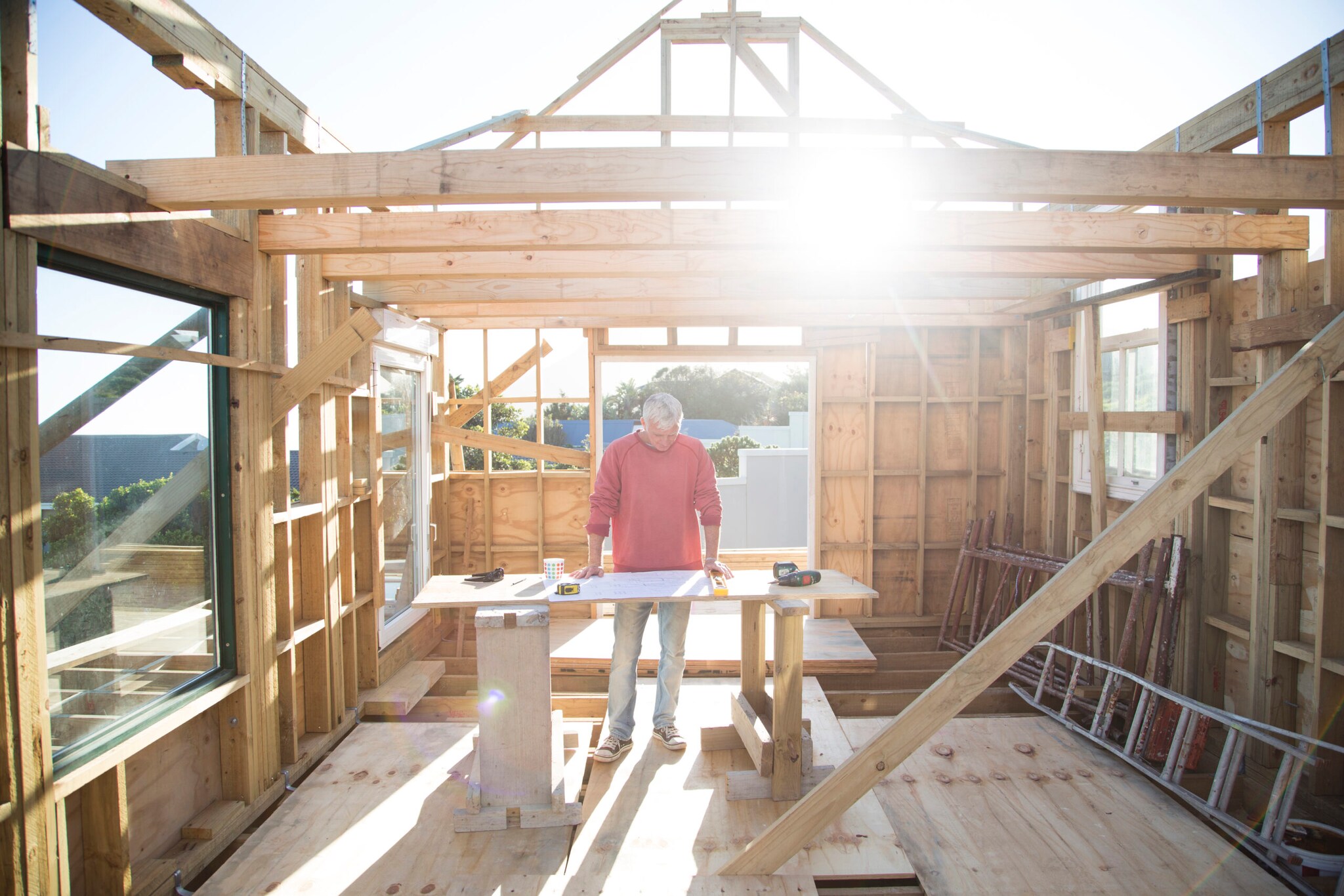 Ein Mann baut ein kleines Haus aus Holz
