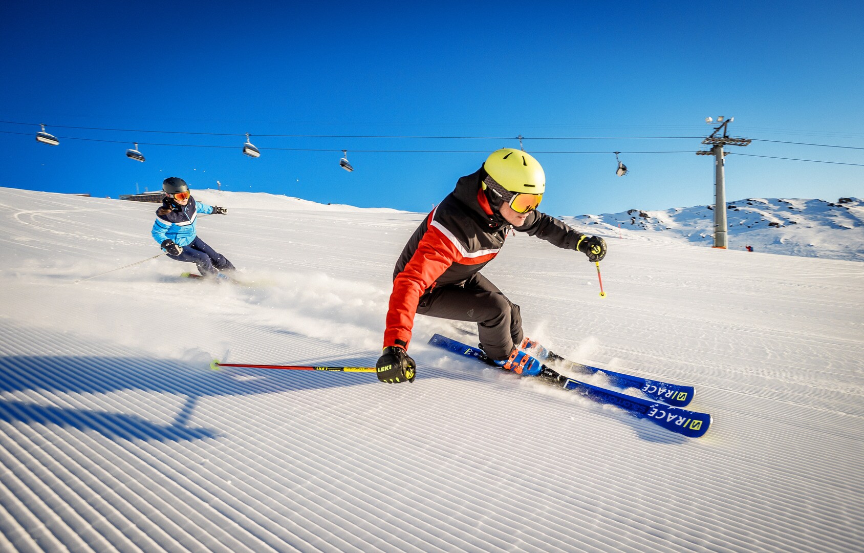Zwei Alpinskifahrer:innen bei der Abfahrt in Parsenn