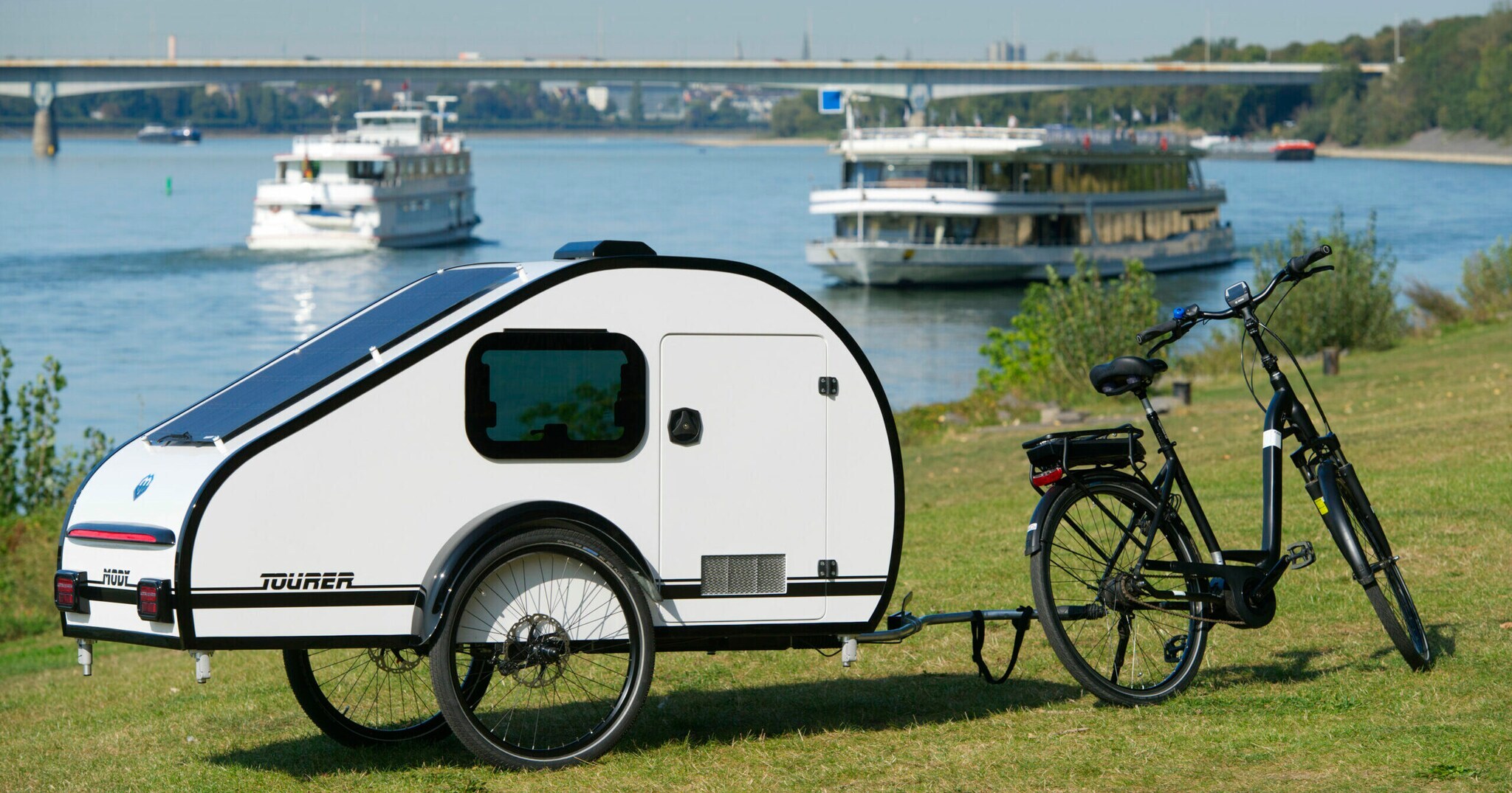Ein Wohnwagen-Anhänger ist an einem Fahrrad befestigt