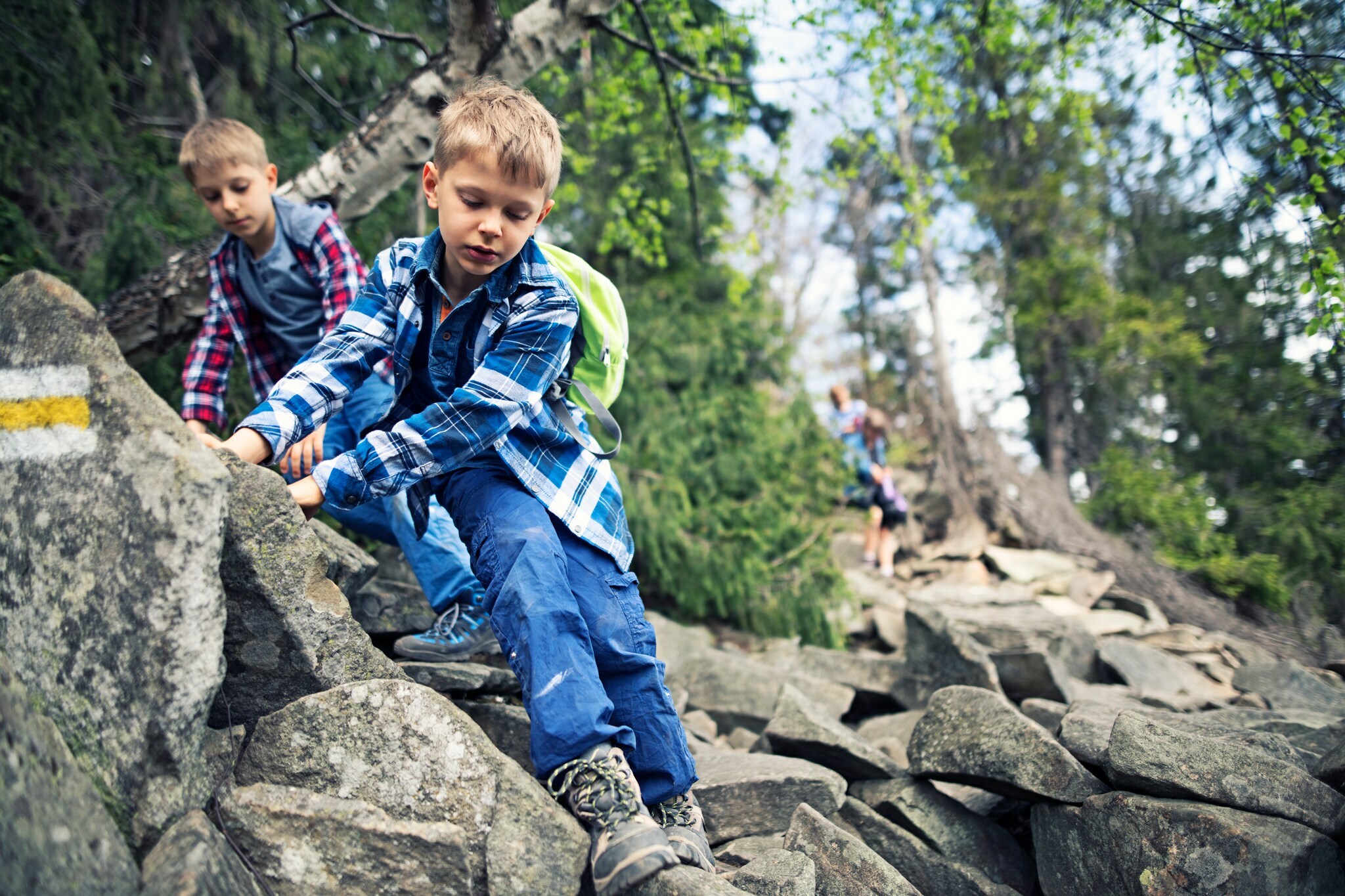 Kinder klettern einen steinigen und felsigen Hang entlang