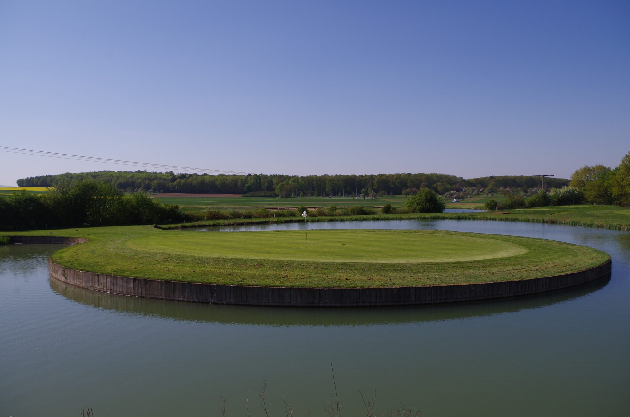 Ein rundes, fast komplett von Wasser umgebenes, Putting Green