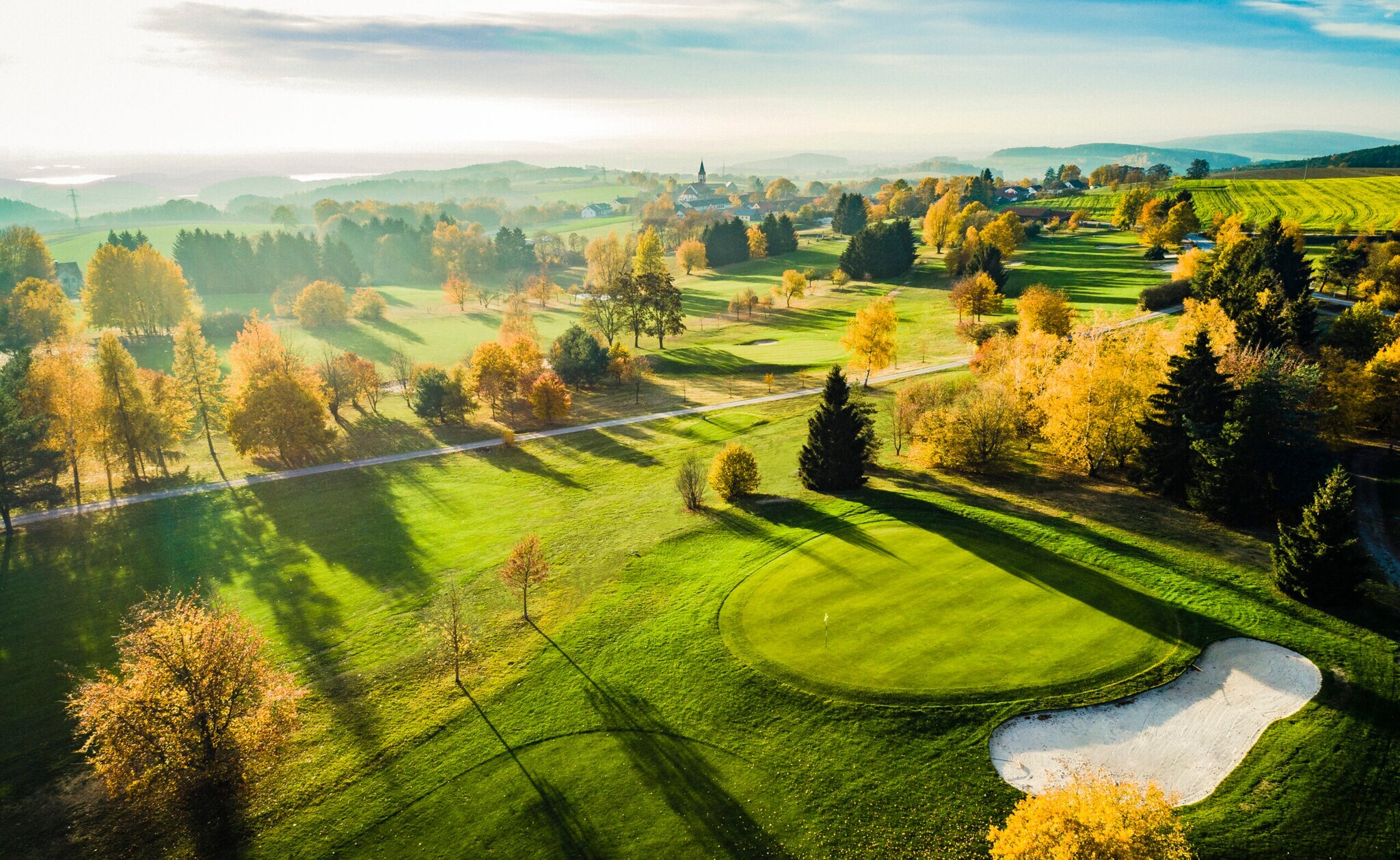 Blick auf Landschaft mit Golfplatz in der Abendsonne