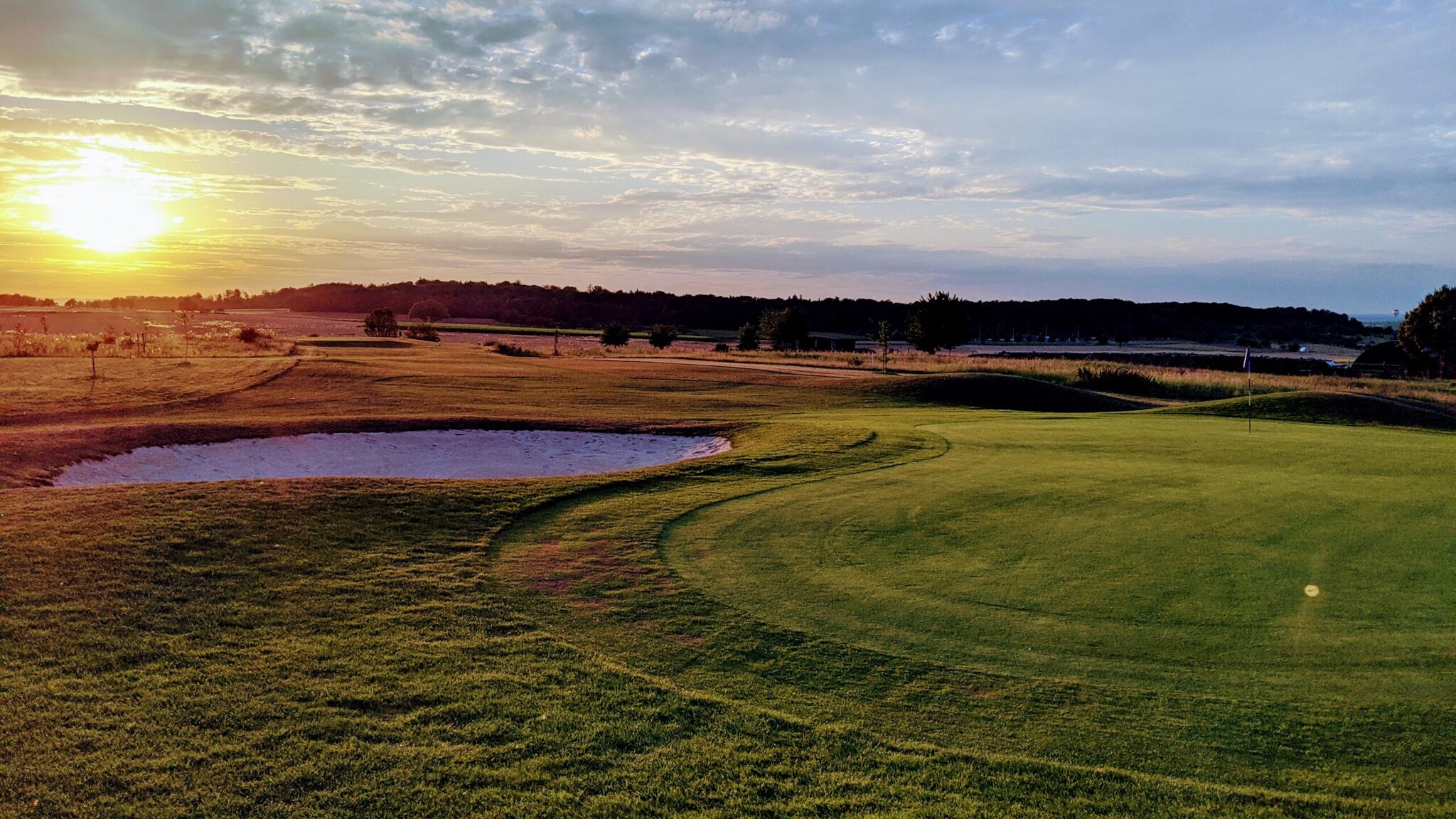 Ein Golfplatz mit Bunker bei Sonnenuntergang
