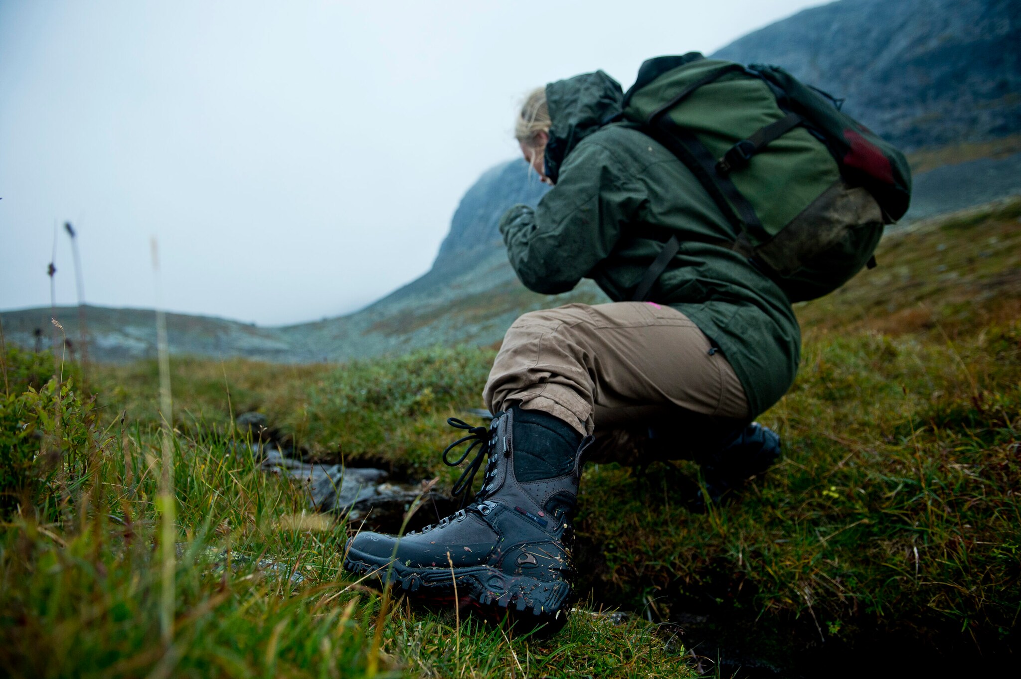 Frau mit Wanderschuhen in regnerischer Berglandschaft