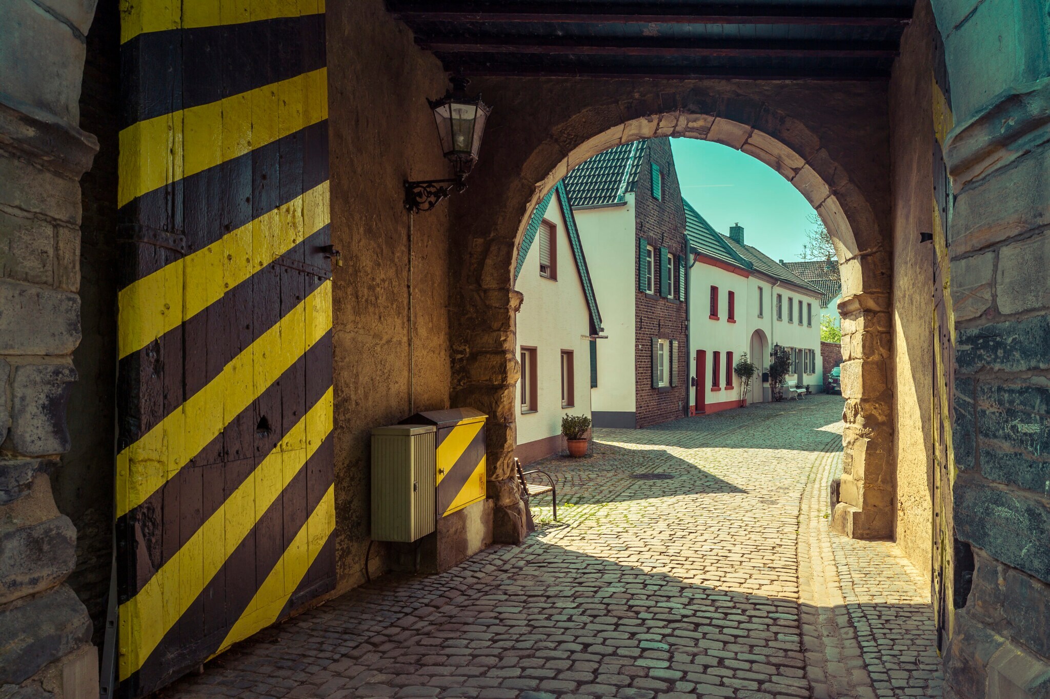 Ein historisches Stadttor mit gelb-schwarz gestreifter Tür