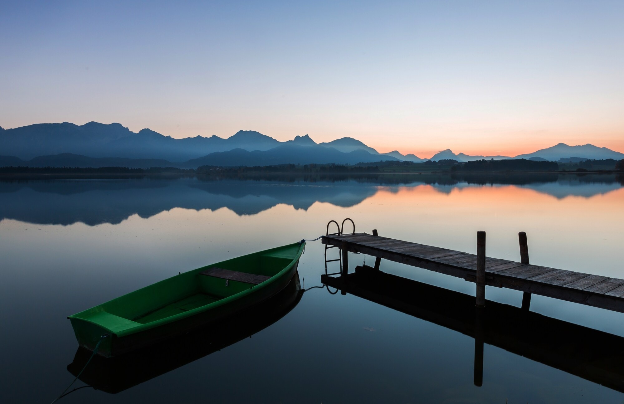 Der See Hopfen in den Bayerischen Alpen mit Boot und Steg bei Dämmerung Der See Hopfen in den Bayerischen Alpen mit Boot und Steg bei Dämmerung