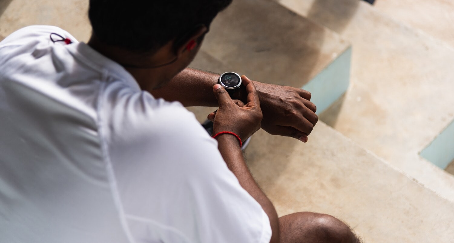Ein Mann in Sportkleidung mit Armbanduhr mit Digitalanzeige am Handgelenk Ein Mann in Sportkleidung mit Armbanduhr mit Digitalanzeige am Handgelenk