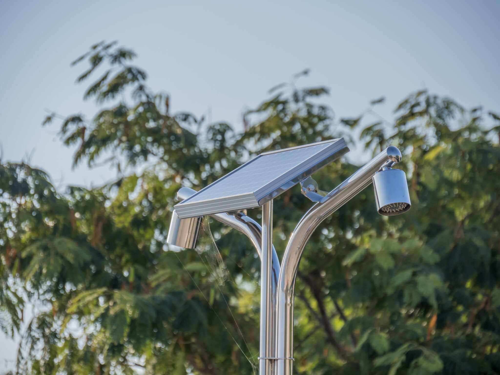 Detailaufnahme einer Dusche mit Solarpanel im Freien Detailaufnahme einer Dusche mit Solarpanel im Freien