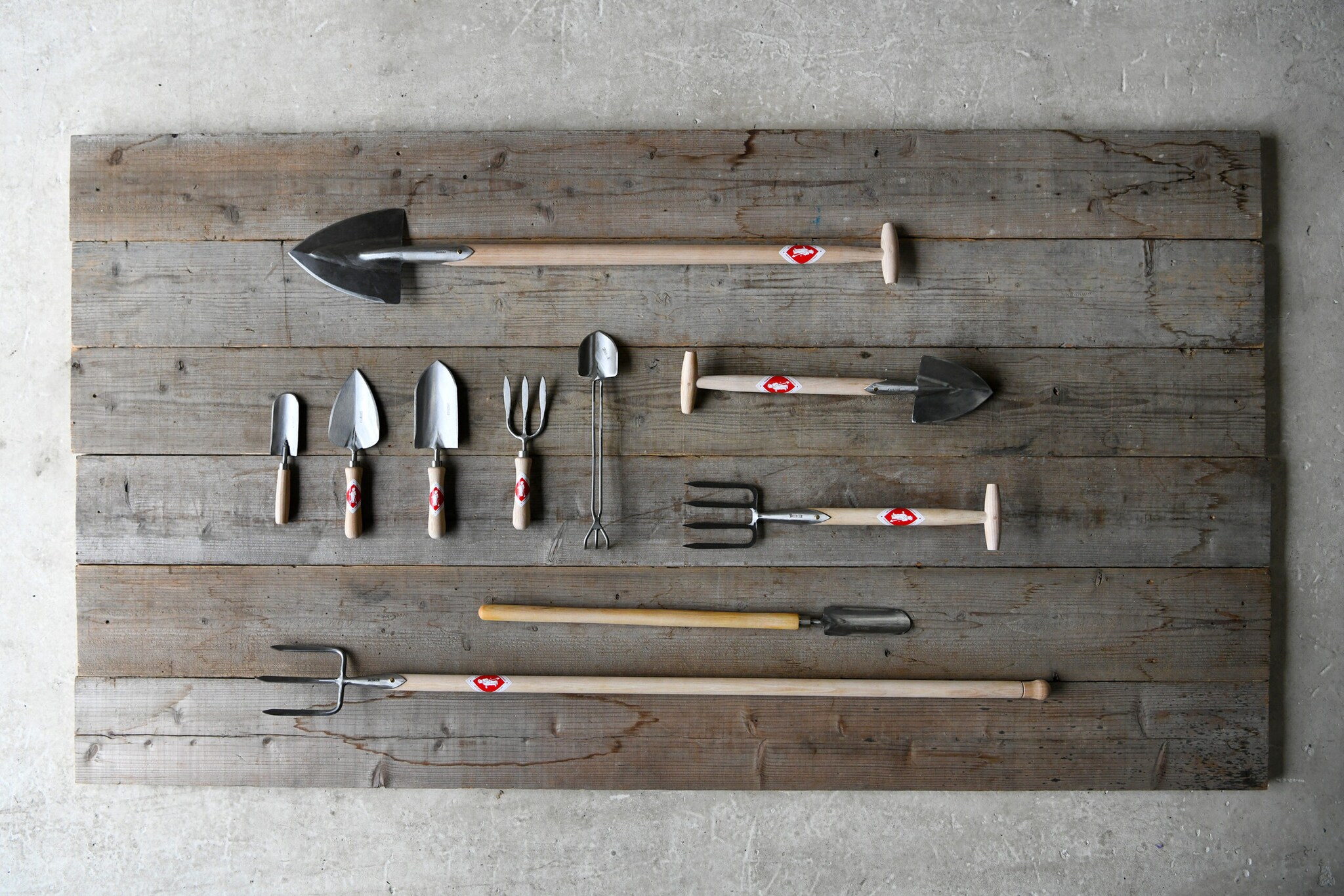 Aufsicht verschiedener Gartenwerkzeuge auf einer Holzfläche Aufsicht verschiedener Gartenwerkzeuge auf einer Holzfläche