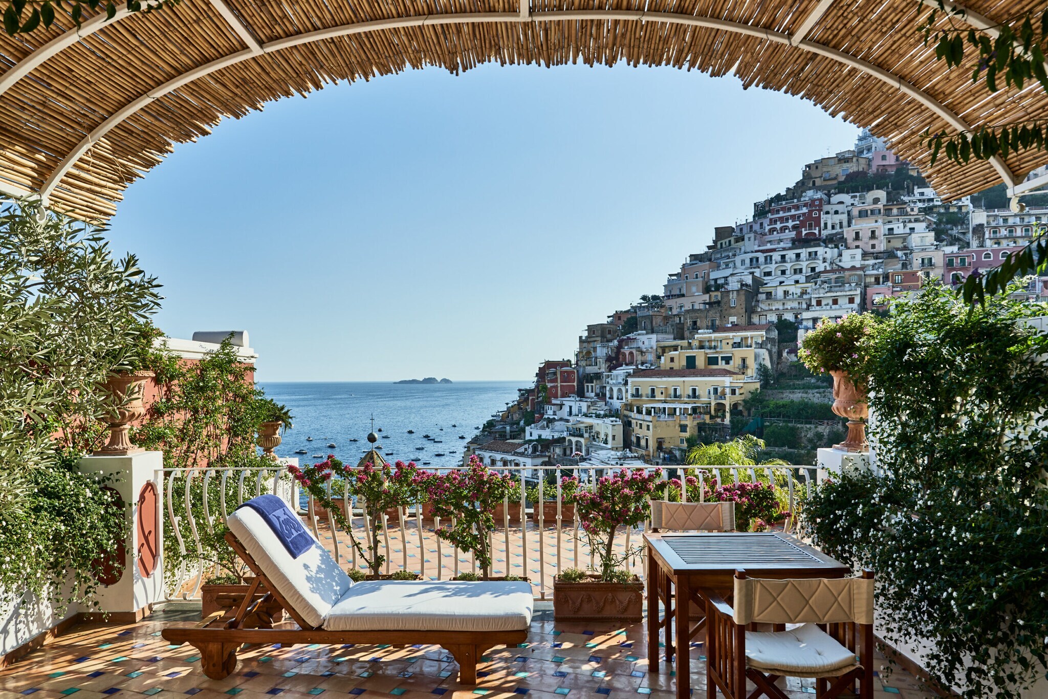 Die überdachte private Sonnenterrasse eines Zimmers mit Blick auf Positano und das Meer