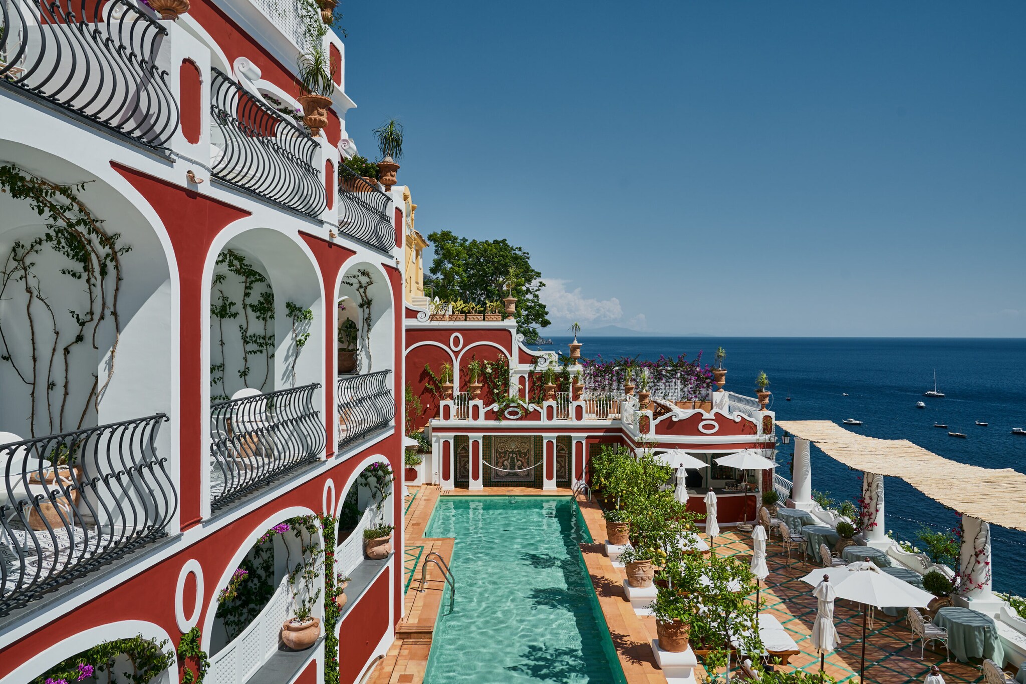 Hotel Le Sirenuse: Blick auf die terrakottafarbene Fassade und die Terrasse mit Pool und Meersicht Hotel Le Sirenuse: Blick auf die terrakottafarbene Fassade und die Terrasse mit Pool und Meersicht